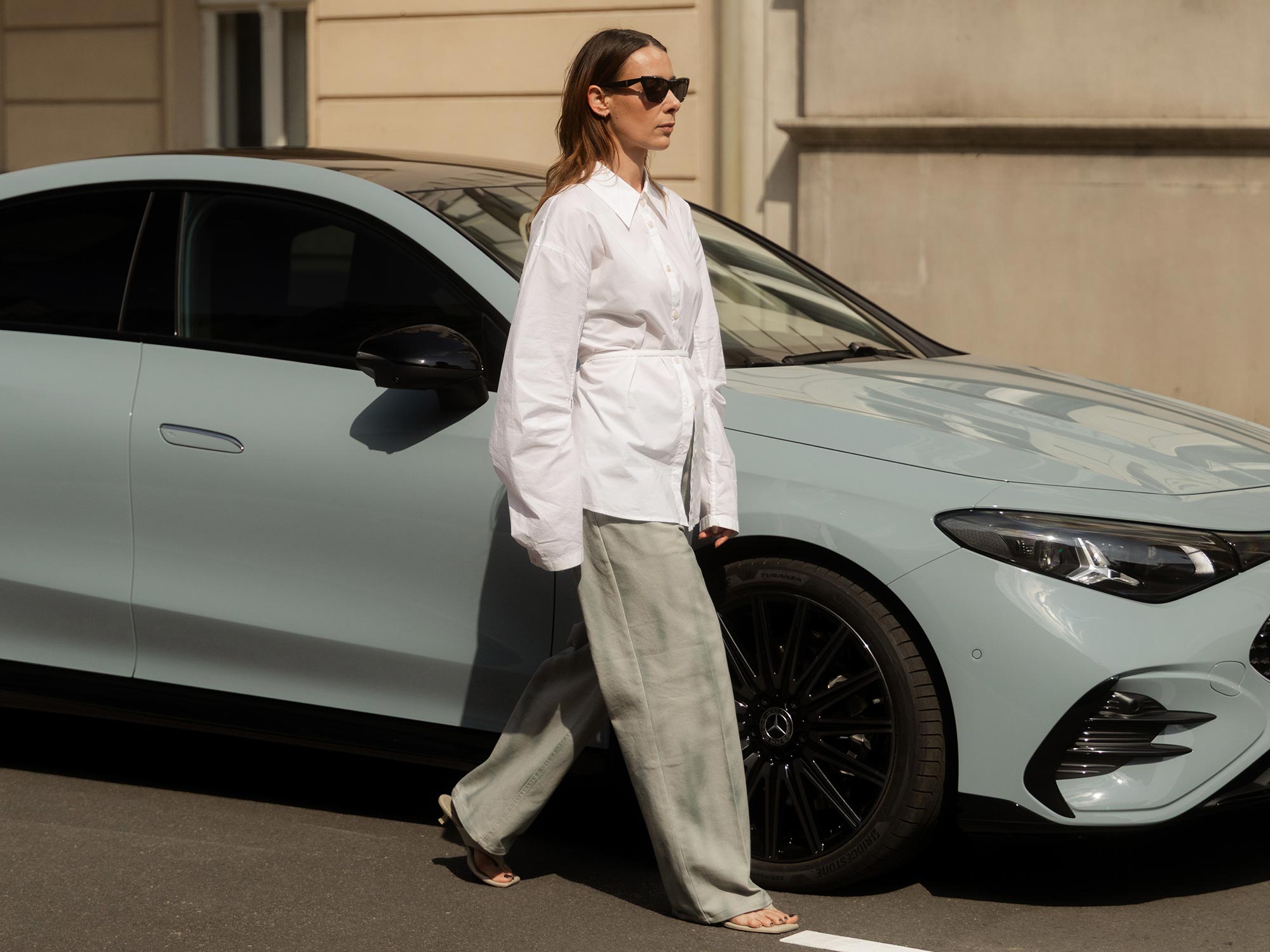 Stilvolle Frau im urbanen Umfeld Stilvoll gekleidete Frau neben einem grauen Mercedes-Benz.