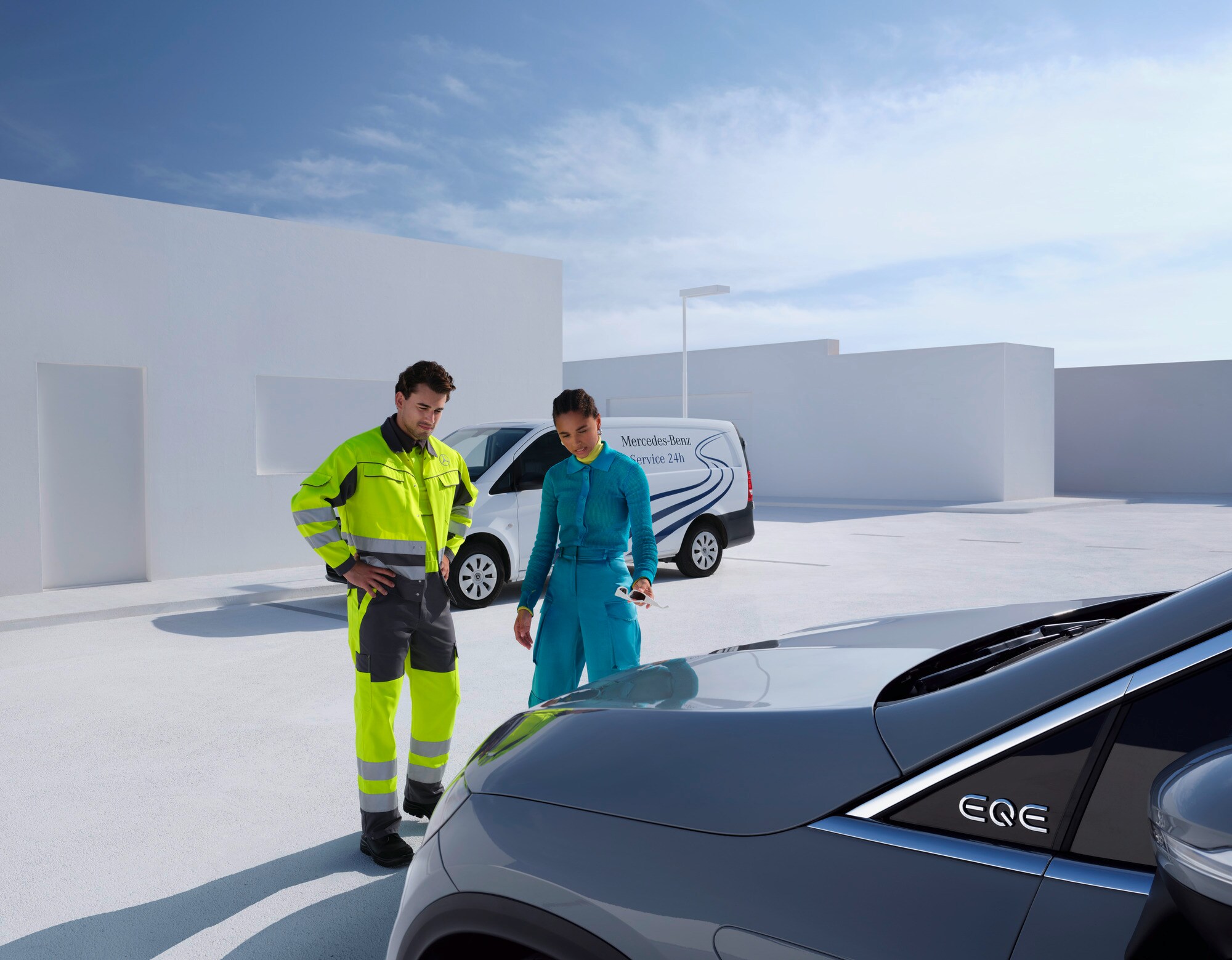 Assistance dépannage | Mercedes-Benz Une personne de l'équipe d'assistance de Mercedes-Benz Service24 en train de conseiller un client devant un véhicule Mercedes-Benz.