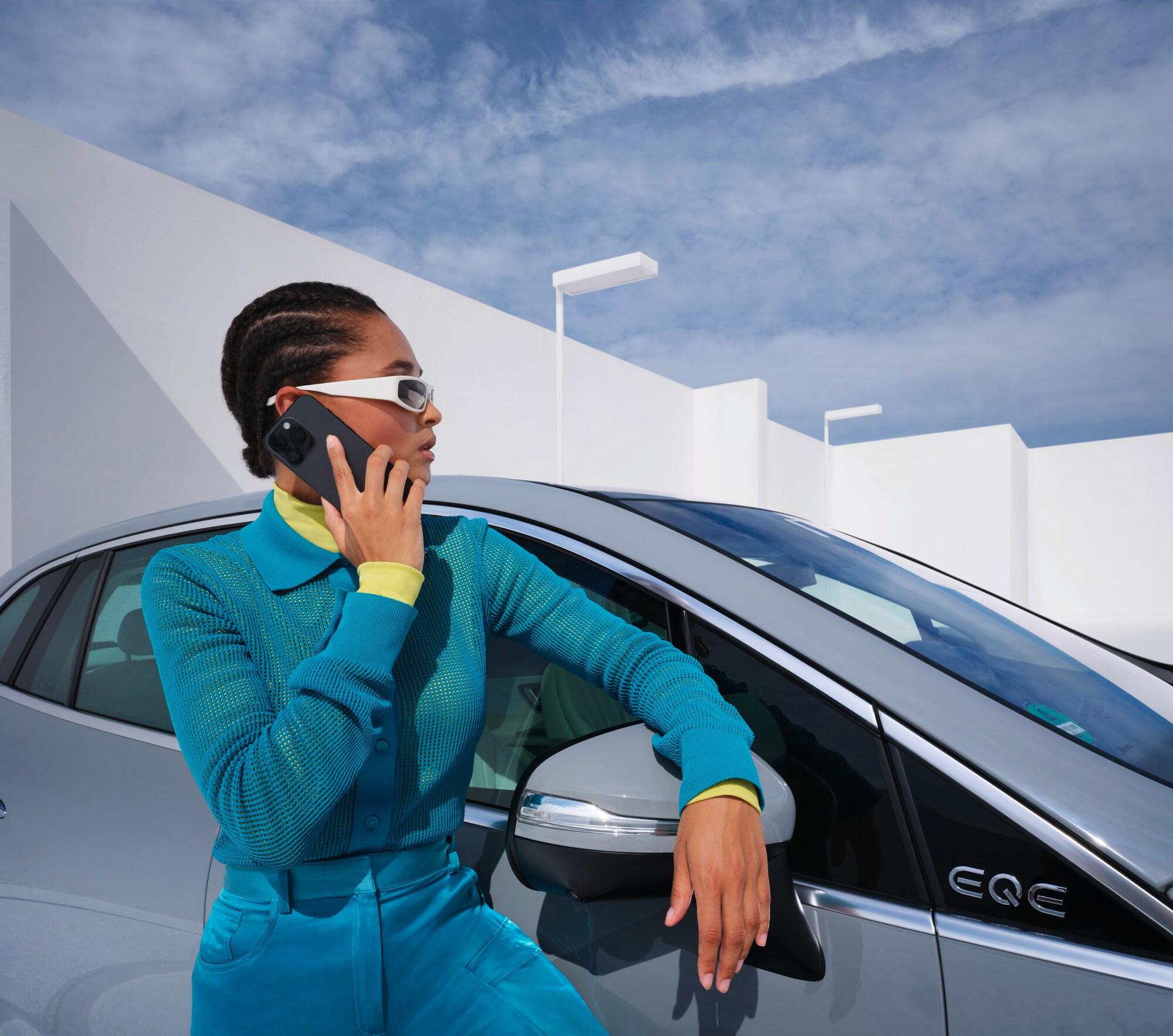 Assistance en cas d'accident et de panne | Mercedes-Benz Une personne s'appuyant sur un véhicule Mercedes-Benz, le téléphone à la main.