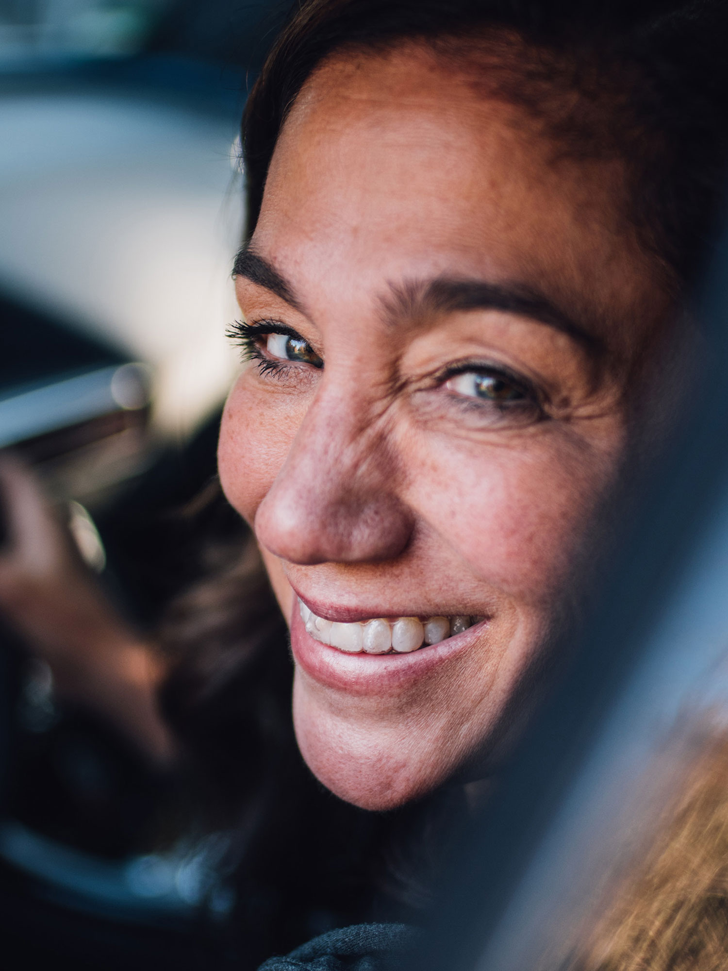 She's Mercedes Donna sorridente al volante di una Mercedes – vista attraverso la porta del conducente.